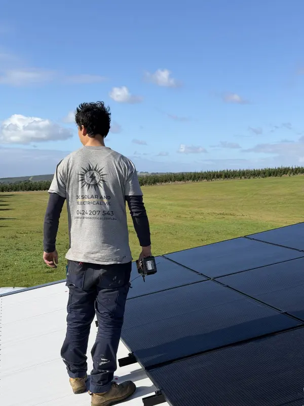 JC Solar electrician beside a rooftop solar array